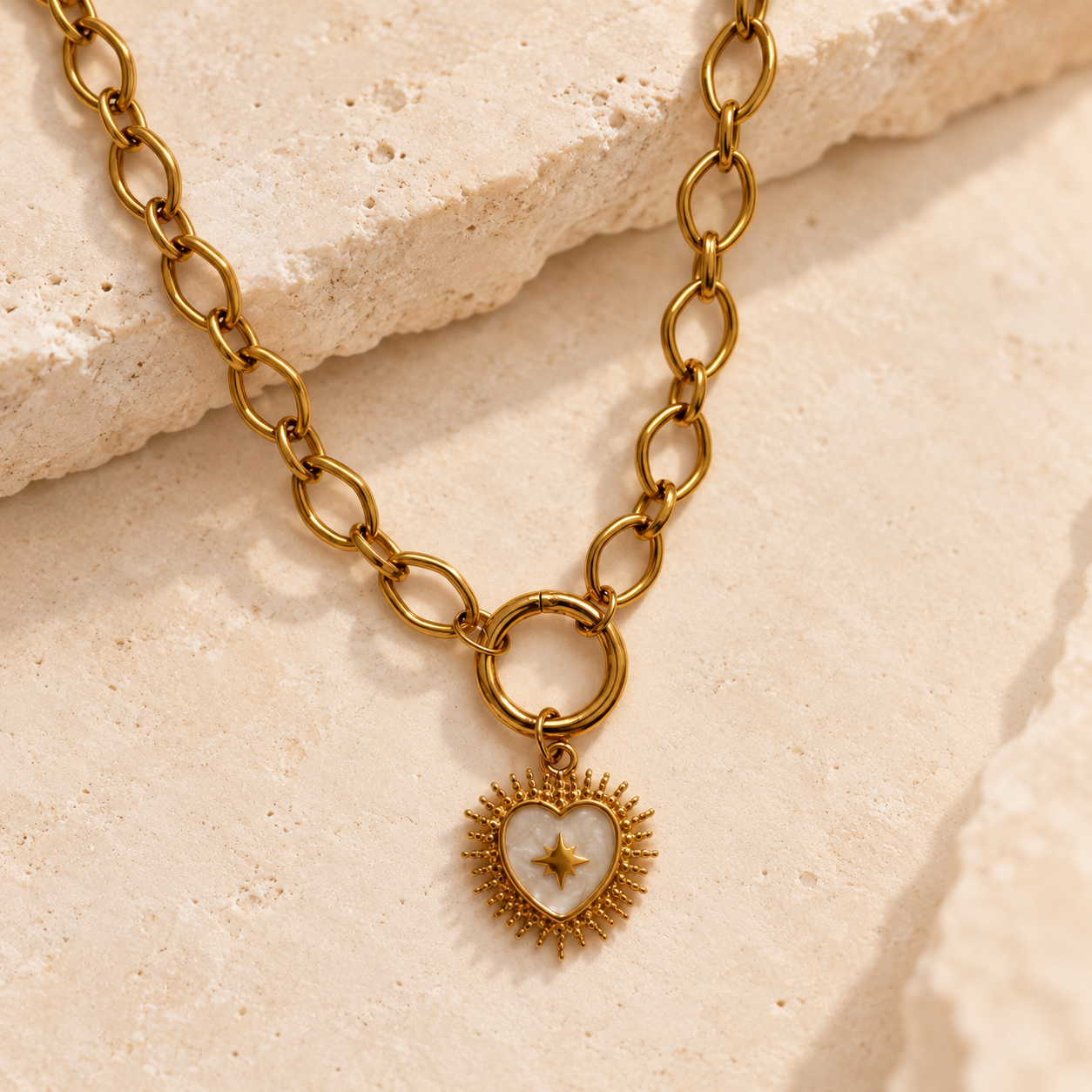Gold oval carabiner necklace with a detachable heart starburst charm 