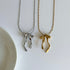 Two necklaces with bow pendants, one silver and one gold, on a white background.