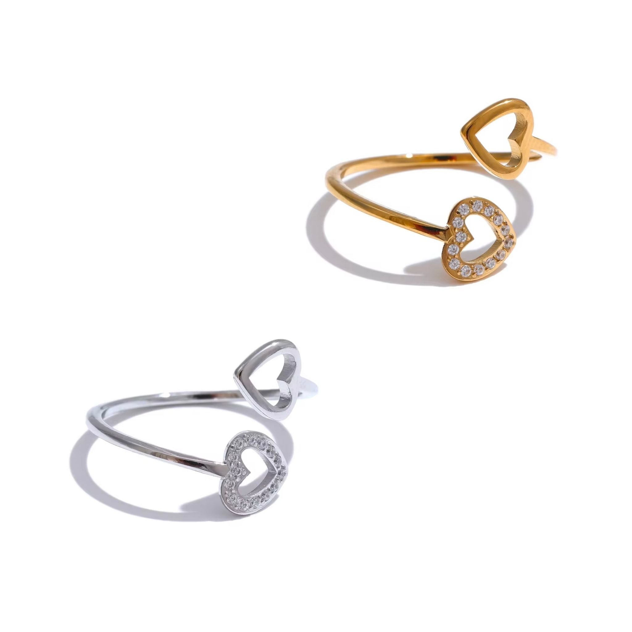 Two heart-shaped rings, one gold and one silver, on a white background.