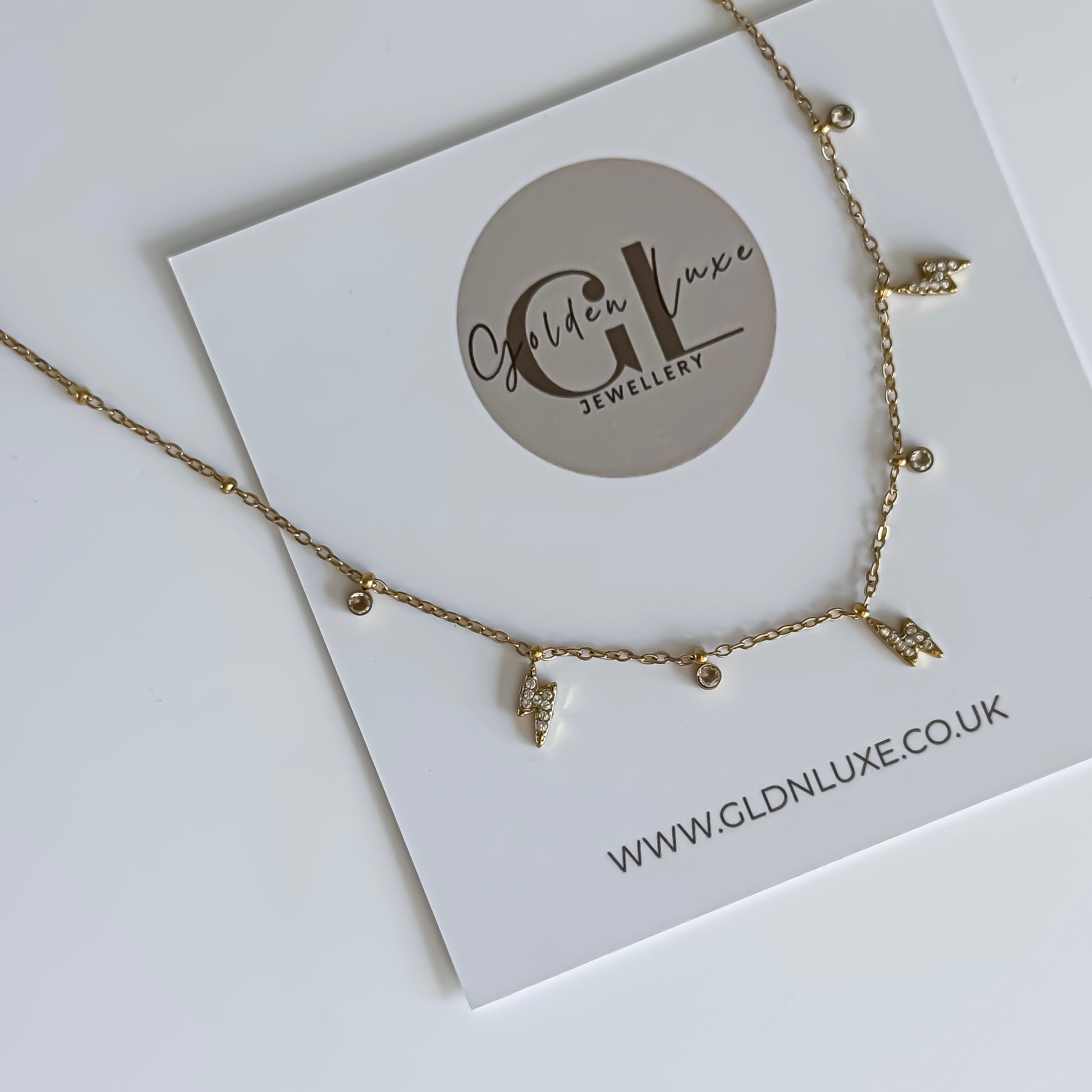 Gold necklace on a Golden Luxe Jewellery card with website URL.