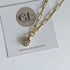 Gold necklace with a pendant on a card featuring 'Golden Luxe Jewellery' and their website.