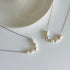Pearl necklace on a white surface with a neutral background