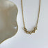 Gold necklace with heart-shaped gemstones on a white surface