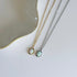 Two opal pendant necklaces on a light background