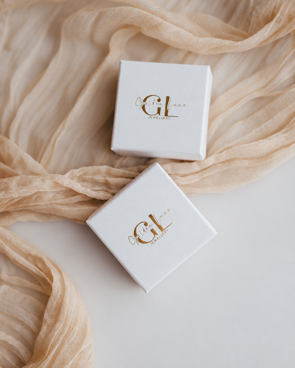 Small white Golden Luxe jewellery gift box featuring elegant gold branding.