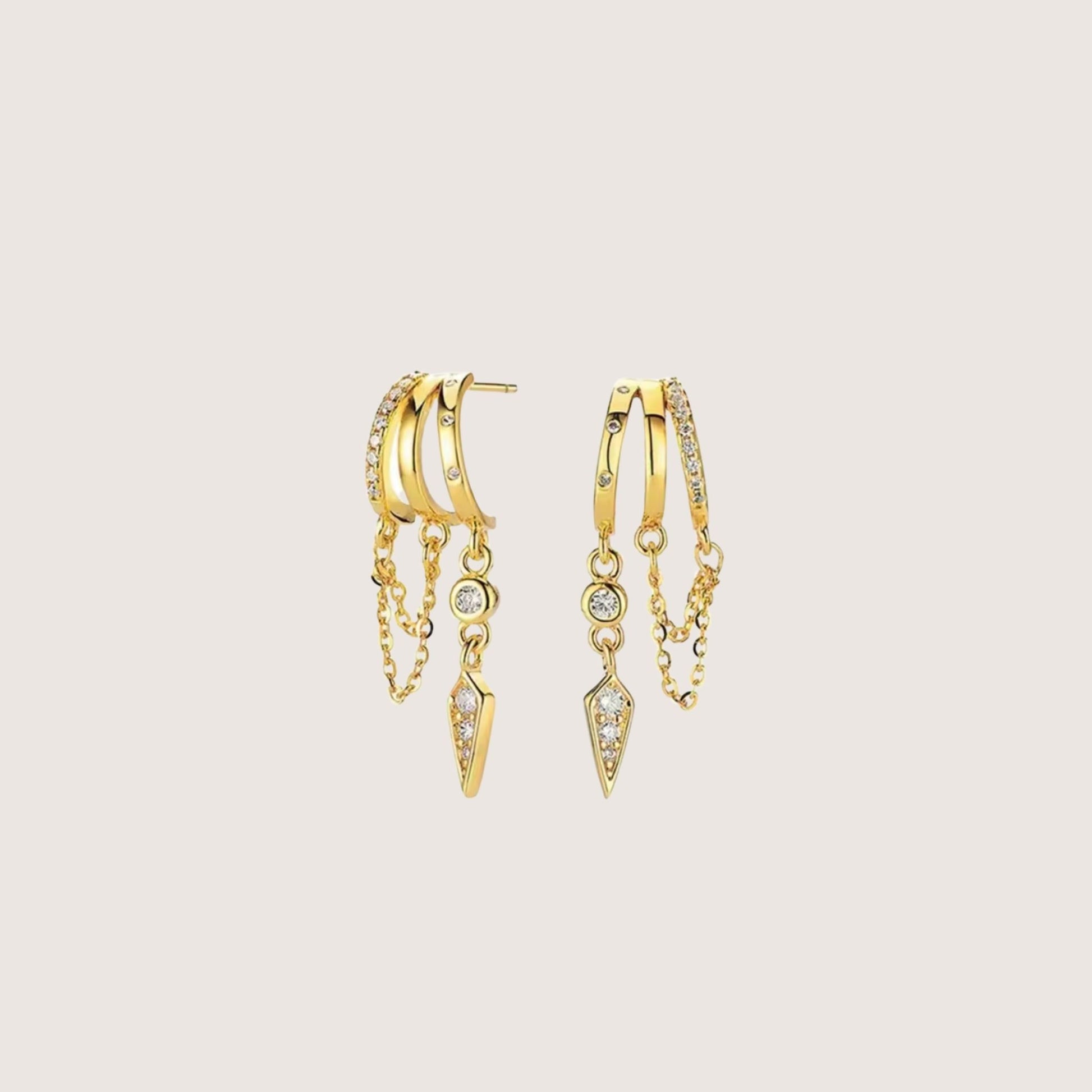 Gold hoop earrings with chain and gemstone details on a beige background