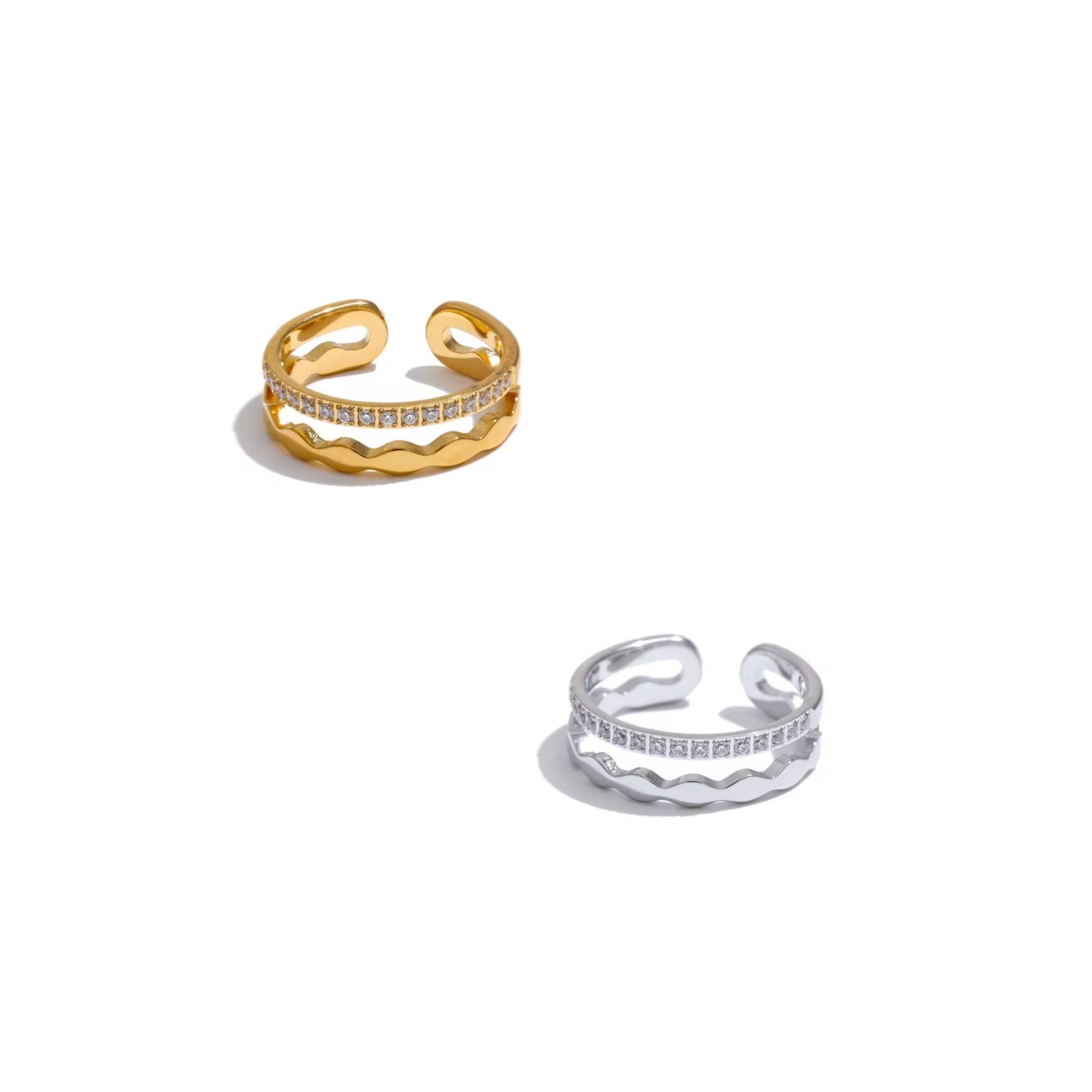 Gold and silver open rings with embedded stones on a white background
